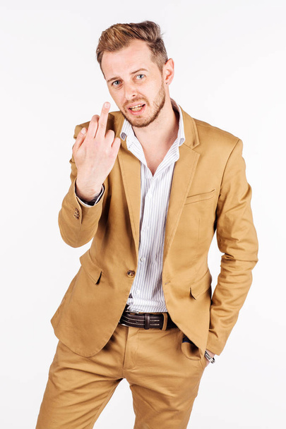 young businessman showing middle finger on white background. human emotion facial expression reaction attitude.  emotion expression and lifestyle concept. - Фото, изображение