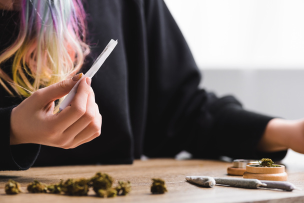 селективное внимание девушки, держащей косяк с марихуаной
 - Фото, изображение