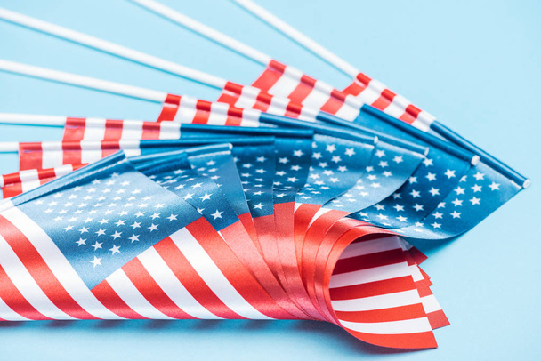 close up view of american flags on sticks on blue background - Valokuva, kuva