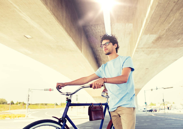 hipster man with fixed gear bike under bridge - Zdjęcie, obraz