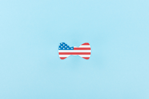 vista dall'alto di papillon decorativo taglio carta fatto di bandiera americana su sfondo blu
  - Foto, immagini