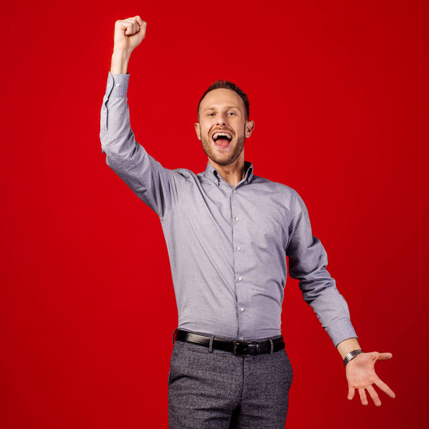 man raising arms fists up isolated on red background. emotion concept. - Foto, Imagem