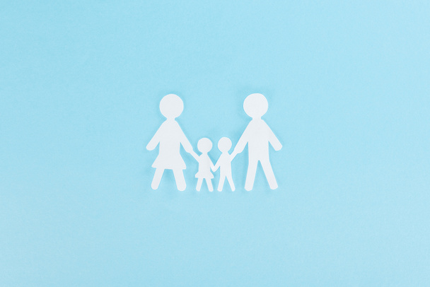 Draufsicht auf weiße Papierschnittfamilie auf blauem Hintergrund  - Foto, Bild
