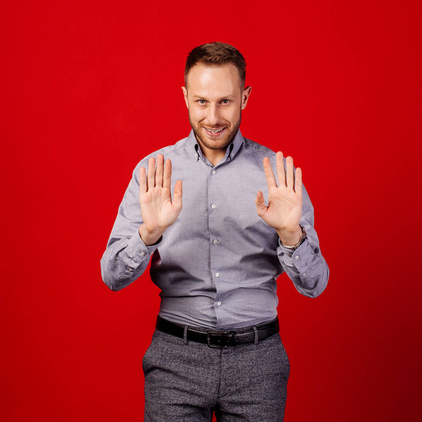 man making stop gesture over red background. emotion and people concept - Fotoğraf, Görsel