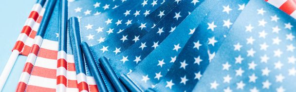 close up view of glossy american flags on blue background, panoramic shot - Foto, imagen