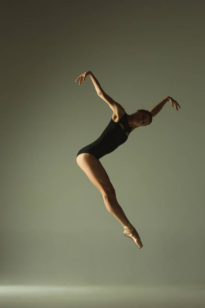 Young graceful female ballet dancer dancing in mixed light - Foto, imagen