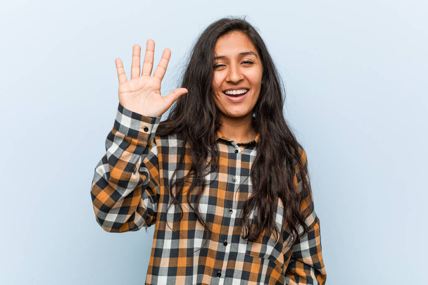 Młoda fajna Hinduska kobieta uśmiecha się radośnie pokazując numer pięć palcami. - Zdjęcie, obraz