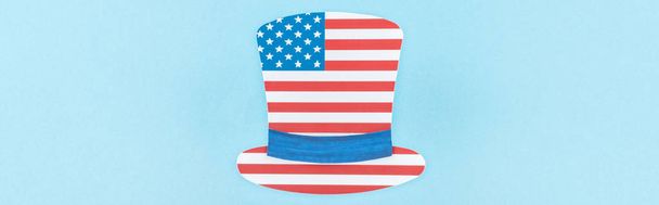 top view of paper cut decorative hat made of american flag on blue background, panoramic shot  - Photo, Image
