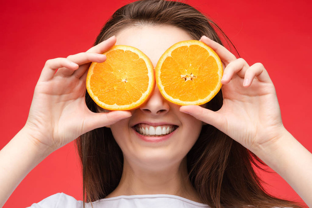 Cheerful young blonde posing with fresh oranges - Fotó, kép