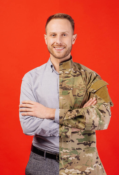 Young soldier in military wear keeping arms crossed and smiling  - Valokuva, kuva