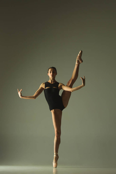 Young graceful female ballet dancer dancing in mixed light - Foto, afbeelding