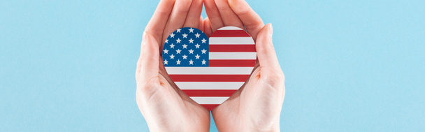panoramic shot of woman holding heart made of american flag on blue background with copy space - Photo, Image