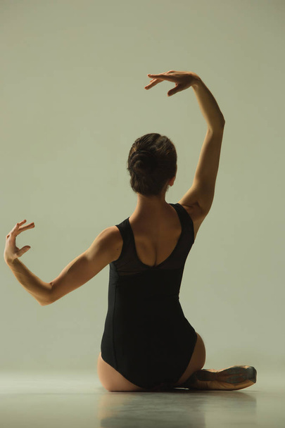 Young graceful female ballet dancer dancing in mixed light - Fotó, kép