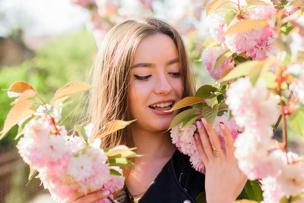 Skincare and spa. Natural cosmetics for skin. Girl in cherry blossom flower. Sakura tree blooming. Soft and tender. Gorgeous flower and female beauty. Pink paradise. Woman in spring flower bloom - Photo, Image