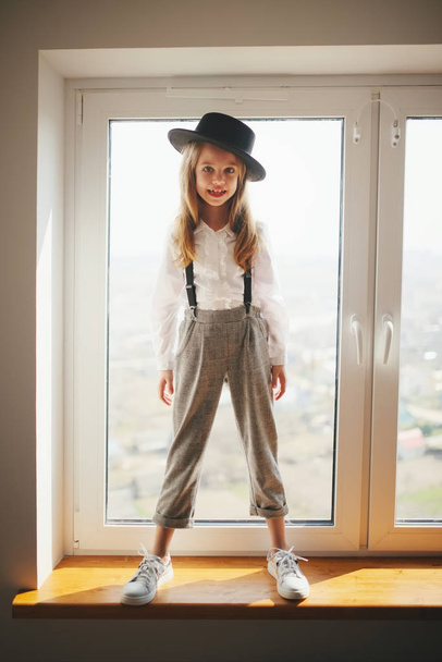 cute little girl with black hat at home - Foto, Imagen