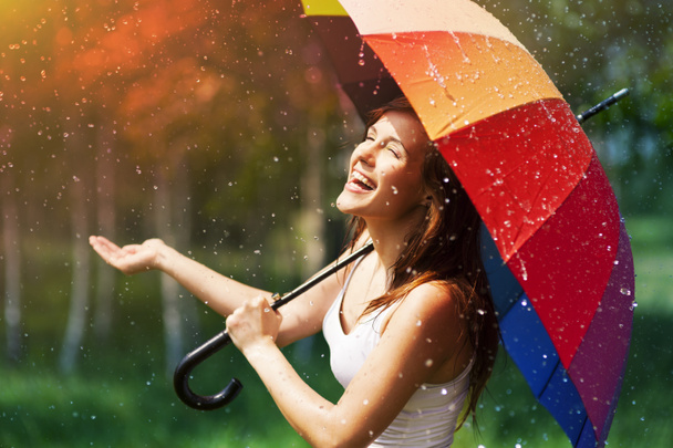 Femme avec parapluie vérifiant la pluie
 - Photo, image