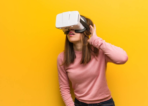 Fiatal aranyos nő visel virtuális valóság googles próbálja hallgatni a pletyka - Fotó, kép
