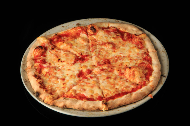 丸い白いプレートにおいしい全体のスライスチーズピザ - 写真・画像