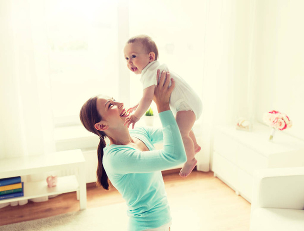happy young mother with little baby at home - Foto, afbeelding