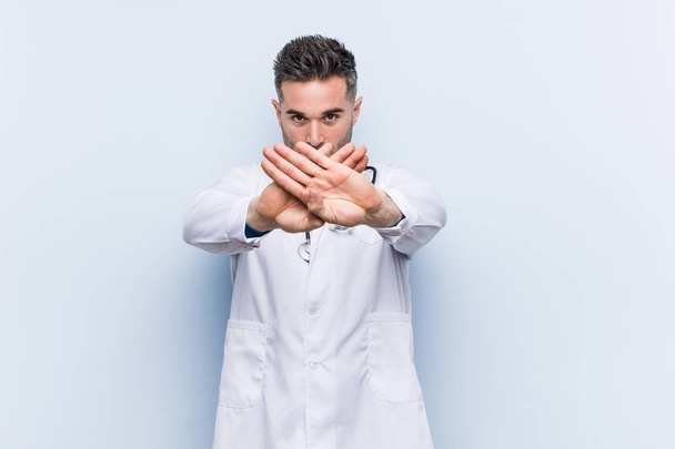Young handsome doctor man doing a denial gesture - Foto, Imagen