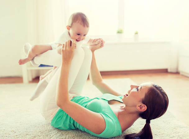 happy mother playing with baby at home - 写真・画像