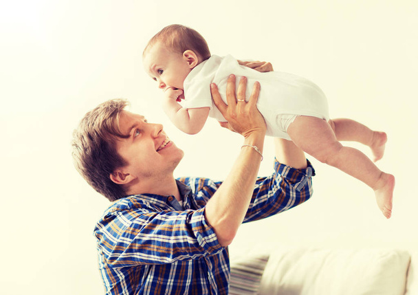happy young father playing with baby at home - Φωτογραφία, εικόνα