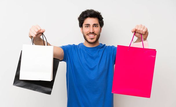 Hombre guapo sosteniendo un montón de bolsas de la compra
 - Foto, imagen