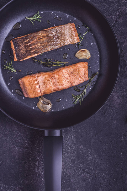 Grilled Salmon Fillets in Black Frying Pan with Rosemary and Garlic - Фото, изображение