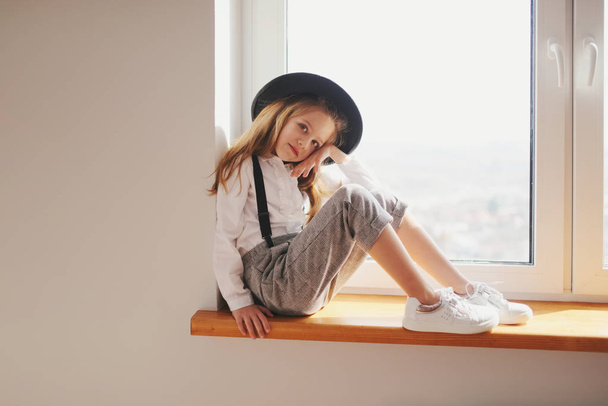 cute little girl with black hat at home - Foto, imagen