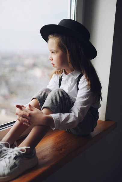 cute little girl with black hat at home - Fotó, kép