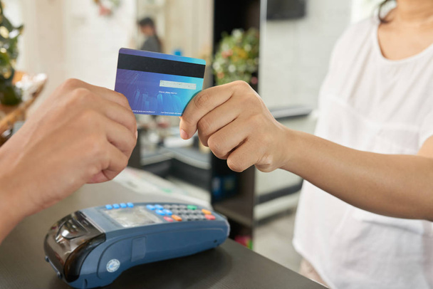 Close-up image of customer paying with card in beauty salon - Valokuva, kuva