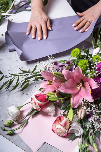 Il lavoro del fiorista nel processo di creazione di un bouquet con gigli
  - Foto, immagini