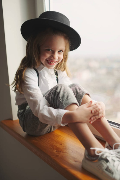 cute little girl with black hat at home - Фото, изображение