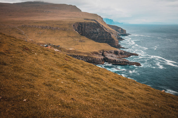  cliffs and the village on the island of Mykines, Faroe. - 写真・画像