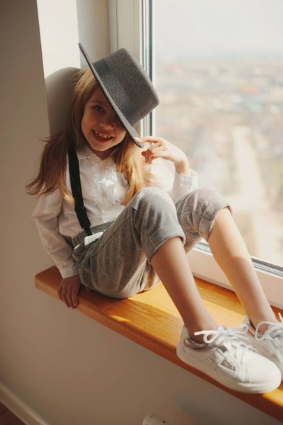 roztomilá holčička s černým kloboukem v domácnosti - Fotografie, Obrázek