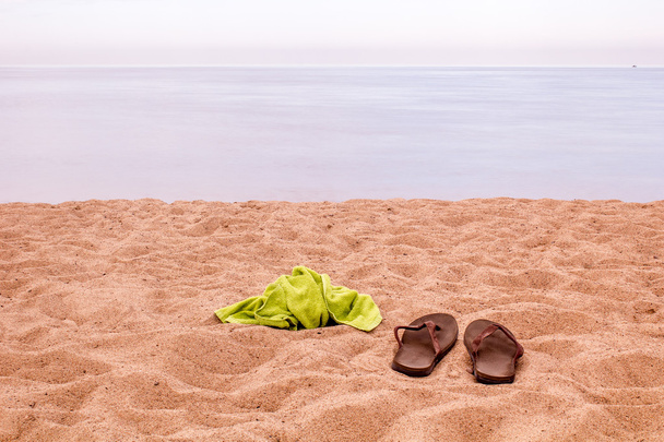 Slippers and a towel on the beach - Photo, Image
