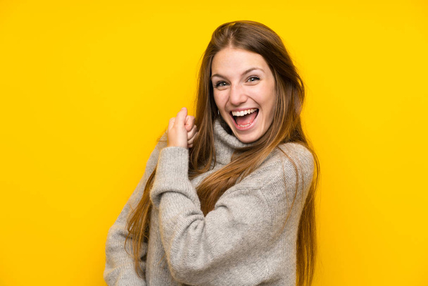 Young woman with long hair over yellow background celebrating a victory - Fotoğraf, Görsel