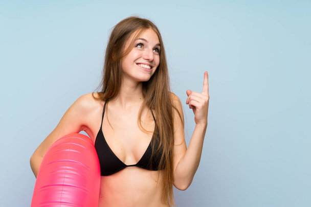 Mujer joven en bikini en vacaciones de verano señalando con el dedo índice una gran idea
 - Foto, Imagen