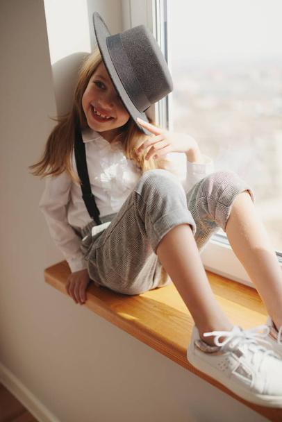 cute little girl with black hat at home - Φωτογραφία, εικόνα