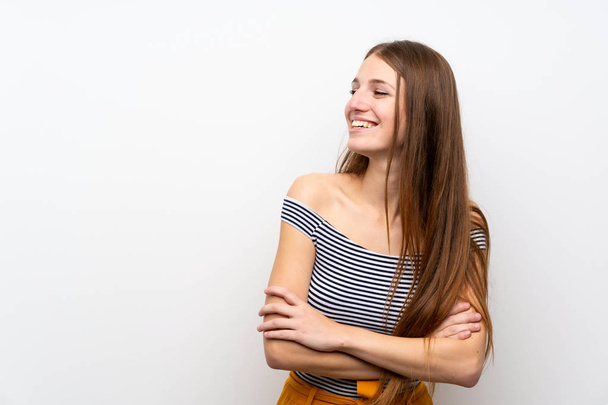 junge Frau mit langen Haaren über isolierter weißer Wand glücklich und lächelnd - Foto, Bild