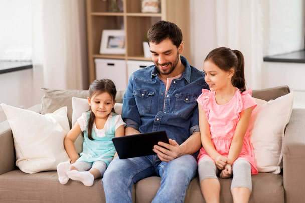 happy father and daughters with tablet pc at home - Φωτογραφία, εικόνα