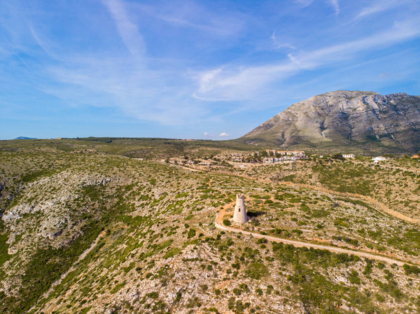 Torre del Gerro torni. Muinainen 1500-luvun vartiotorni kalliolla Deniassa, Espanjassa. Montgo vuori on taustalla
 - Valokuva, kuva