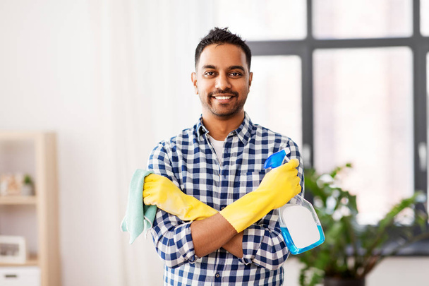 smiling indian man with detergent cleaning at home - Foto, imagen