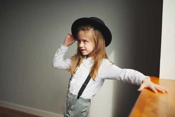 cute little girl with black hat at home - Foto, afbeelding