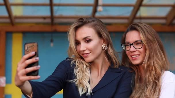 Two attractive women taking selfie on phone and posing - Footage, Video