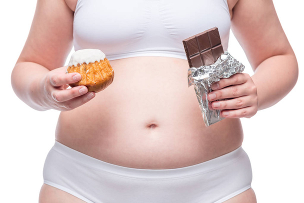 vet meisje met chocolade en muffin in ondergoed, buik close-up - Foto, afbeelding