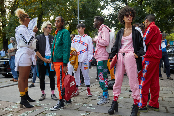 Young men and women with colorful sport clothing with 'Make money not friends' motto before Versace fashion show, Milan Fashion Week street style on September 22, 2017 in Milan. - Фото, изображение