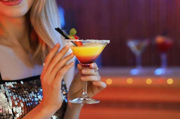 Young woman with glass of martini cocktail in bar, closeup. Space for text - Фото, изображение