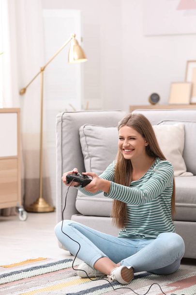 Emotional young woman playing video games at home - Fotó, kép