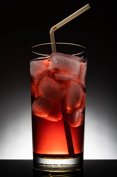 Isolierglas mit rotem Cocktail und Eiswürfeln - Foto, Bild